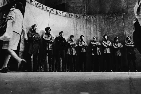 Nine members of the Black Panther Party stand shoulder-to-shoulder at a New York City courthouse wall plaque that reads: "Where law ends there tyranny begins." April 11, 1969. Copyright Hulton Archive/Getty Images